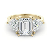 A gold ring with a large, clear gemstone in the center, surrounded by smaller diamonds on either side.