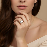 A close-up of a woman's hand wearing a large diamond ring, with her chin resting on her hand.