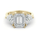 A gold ring with a large, clear gemstone in the center, surrounded by smaller diamonds on either side.