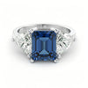 A silver ring with a large blue gemstone in the center, surrounded by smaller diamonds.