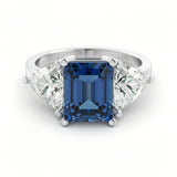 A silver ring with a large blue gemstone in the center, surrounded by smaller diamonds.