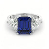 A silver ring with a large blue gemstone in the center, surrounded by smaller diamonds.