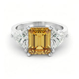 A silver ring with a large yellow gemstone in the center, surrounded by smaller diamonds on either side.