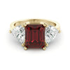 A gold ring with a large red gemstone in the center, flanked by two smaller diamonds on either side.